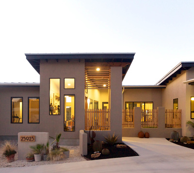A view of the front facade of a stucco home with a tall entry space.